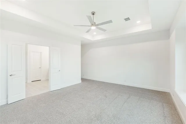 an empty room with ceiling fan and window