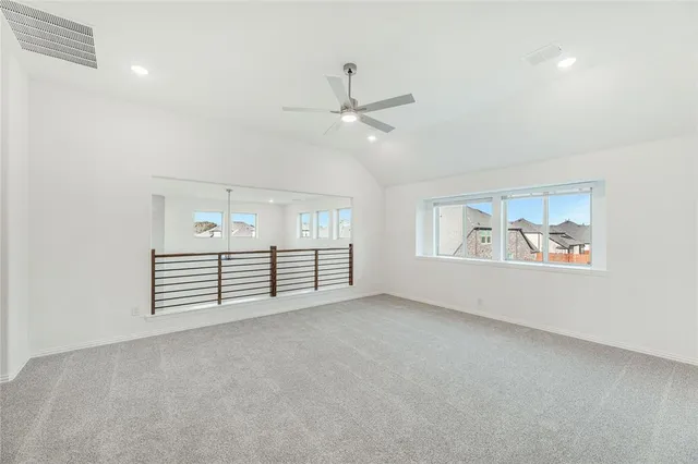 an empty room with windows and ceiling fan