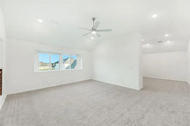 an empty room with fan and windows