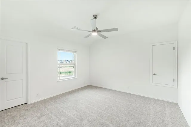 an empty room with a window and a fan