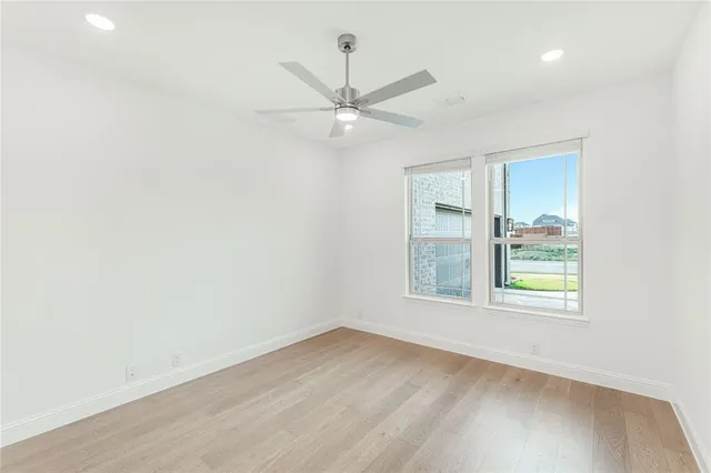 an empty room with a window and ceiling fan