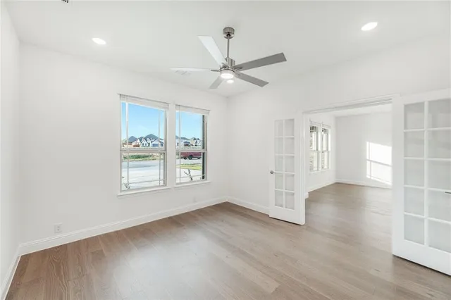 a view of an empty room with a window and wooden floor