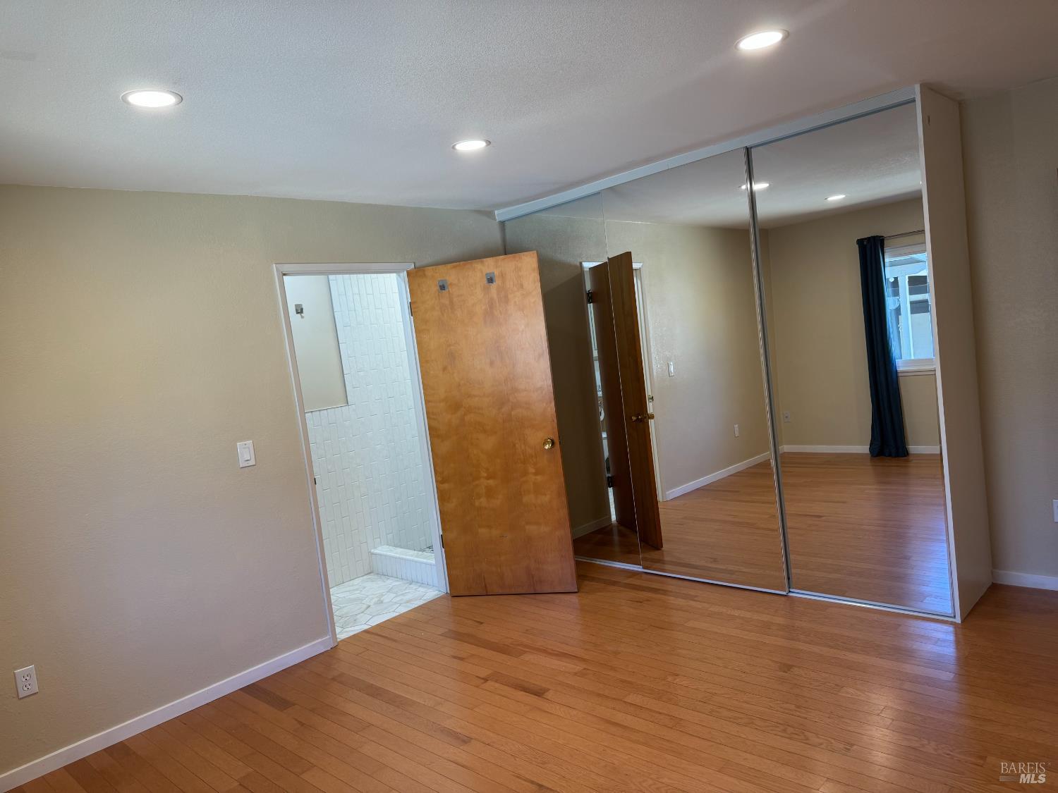 350 Newton Way Angwin, CA 94508 - Photo 22 of 44 a view of a refrigerator in kitchen and an empty room with wooden floor
