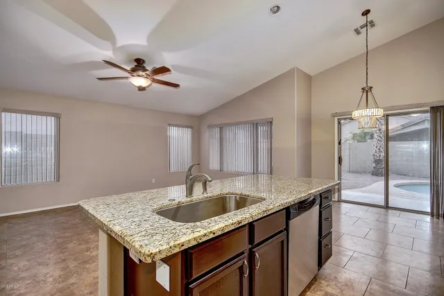 a kitchen with a sink a counter space appliances and cabinets