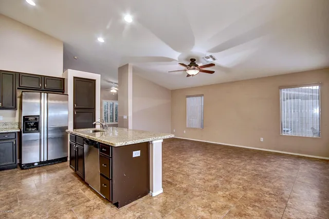 a kitchen with stainless steel appliances granite countertop a sink and a refrigerator