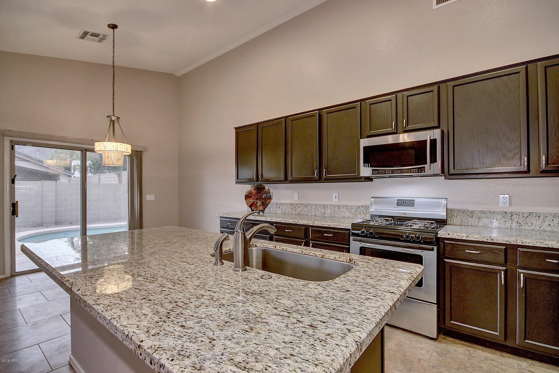 16056 South 18th Avenue Phoenix, AZ 85045 - Photo 14 of 37 a kitchen with stainless steel appliances granite countertop a sink microwave and stove