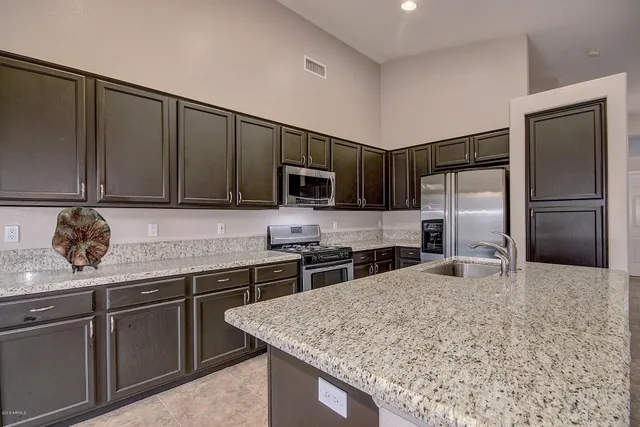 a kitchen with stainless steel appliances granite countertop a sink stove and refrigerator