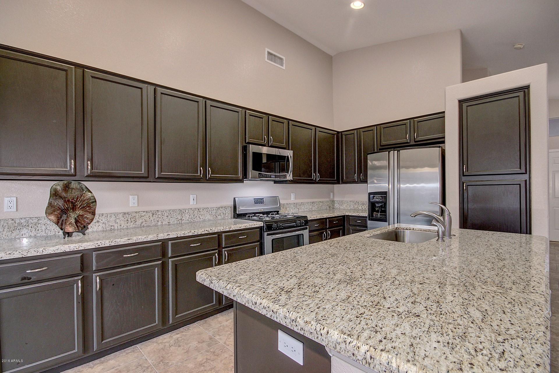 16056 South 18th Avenue Phoenix, AZ 85045 - Photo 15 of 37 a kitchen with stainless steel appliances granite countertop a sink stove and refrigerator