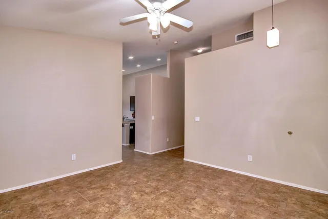an empty room with a ceiling fan and a window