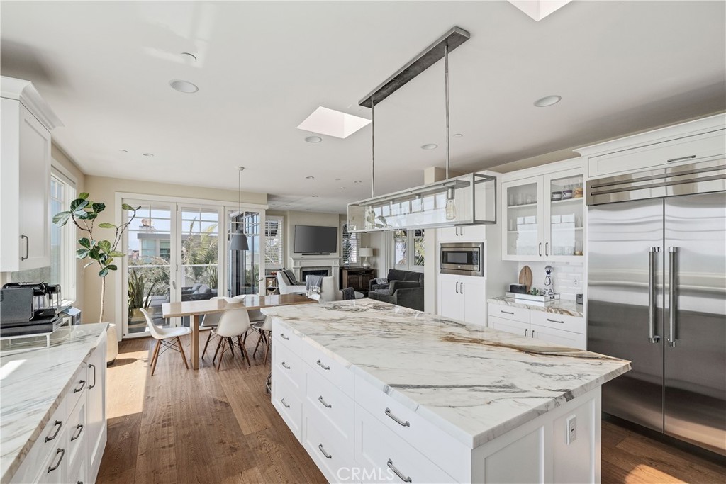 124 23rd Street Manhattan Beach, CA 90266 - Photo 9 of 46 a large kitchen with kitchen island a large counter space a sink appliances and living room view