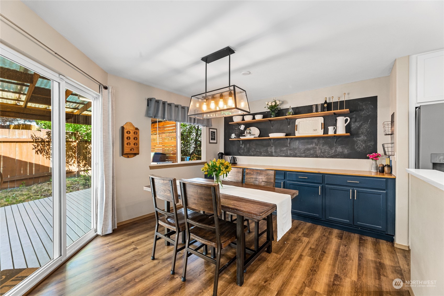 17716 8th Place West Bothell, WA 98012 - Photo 9 of 27 a dining room with wooden floor a chandelier a wooden table and chairs