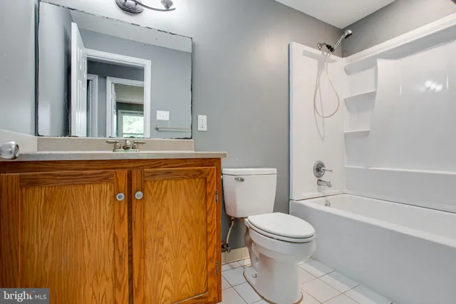 a bathroom with a granite countertop sink toilet mirror and shower