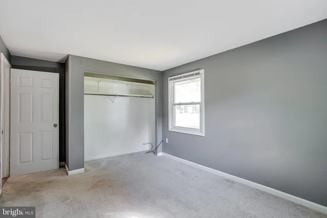 an empty room with windows and closet