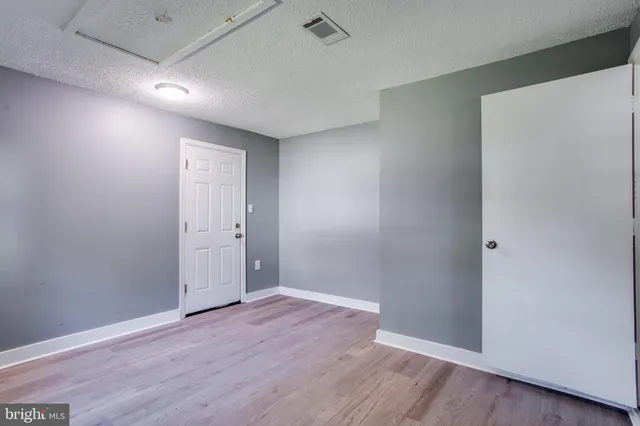a view of an empty room with wooden floor
