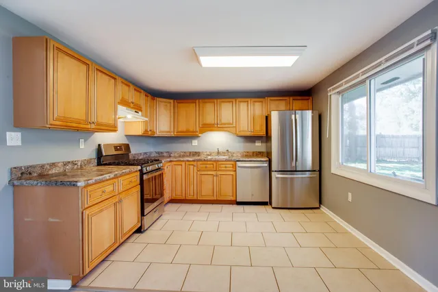 a kitchen with a stove a sink dishwasher and a refrigerator