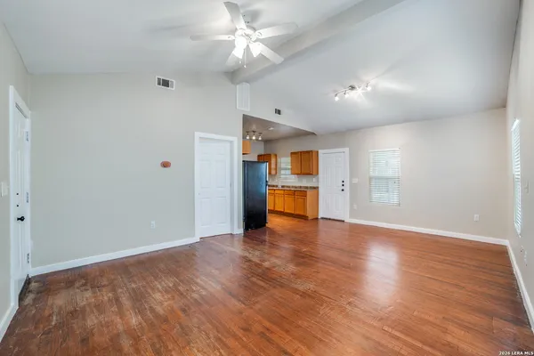 a view of an empty room with a window and wooden floor
