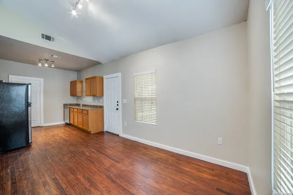 an empty room with wooden floor and windows