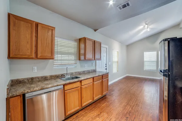 a kitchen with stainless steel appliances granite countertop wooden cabinets a sink and dishwasher