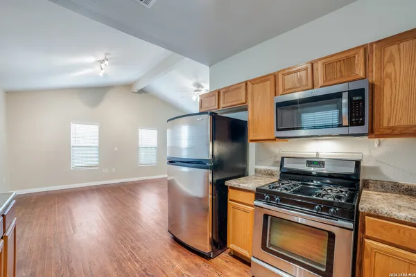 a kitchen with granite countertop a stove and a microwave