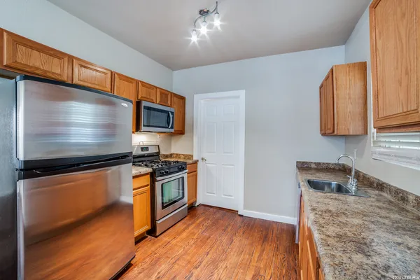 a kitchen with stainless steel appliances granite countertop a stove a sink and a microwave