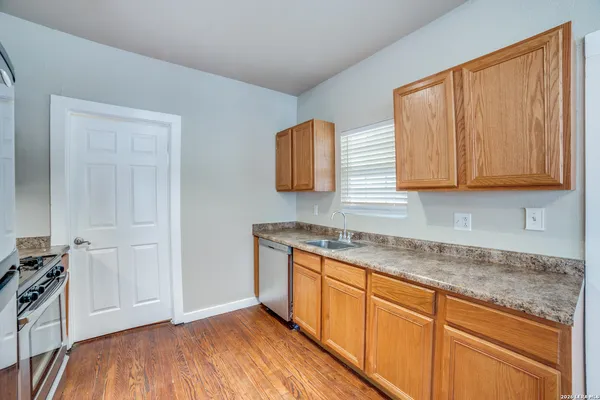 a kitchen with granite countertop wooden cabinets and a sink