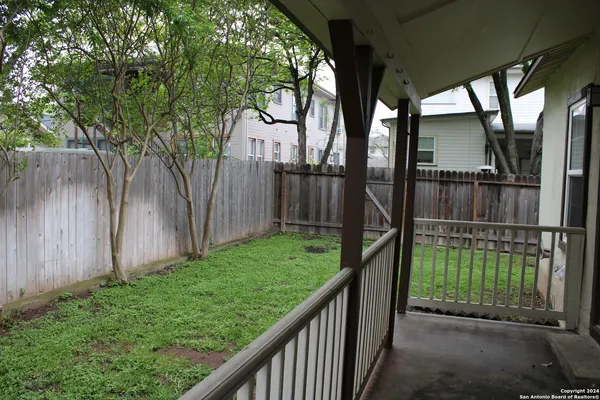 a view of backyard with small cabin and wooden fence
