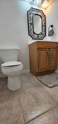 a bathroom with a toilet mirror vanity and mirror