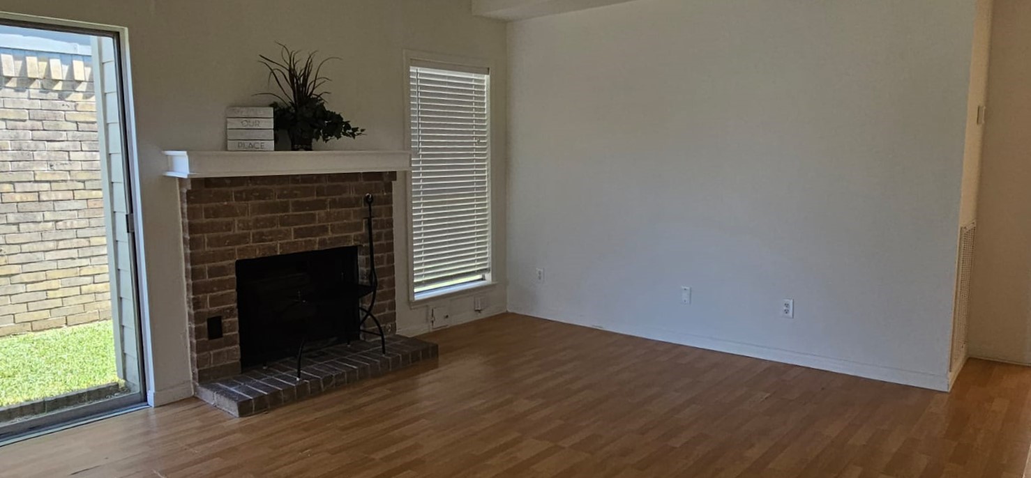 11841 Spring Grove Drive Houston, TX 77099 - Photo 6 of 28 an empty room with wooden floor a fireplace and windows