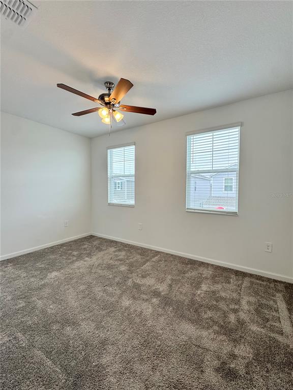 6473 Pine Warbler Way St. Cloud, FL 34771 - Photo 17 of 27 an empty room with windows and fan