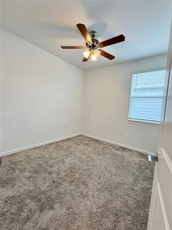 6473 Pine Warbler Way St. Cloud, FL 34771 - Photo 19 of 27 an empty room with windows and fan