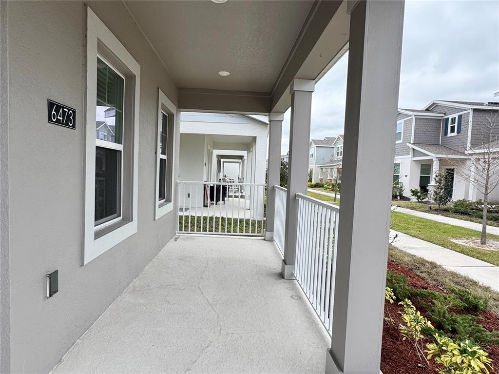 6473 Pine Warbler Way St. Cloud, FL 34771 - Photo 23 of 27 a view of a porch with a floor to ceiling window and a yard
