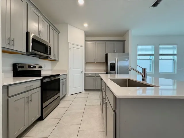 a kitchen with a sink a stove and cabinets