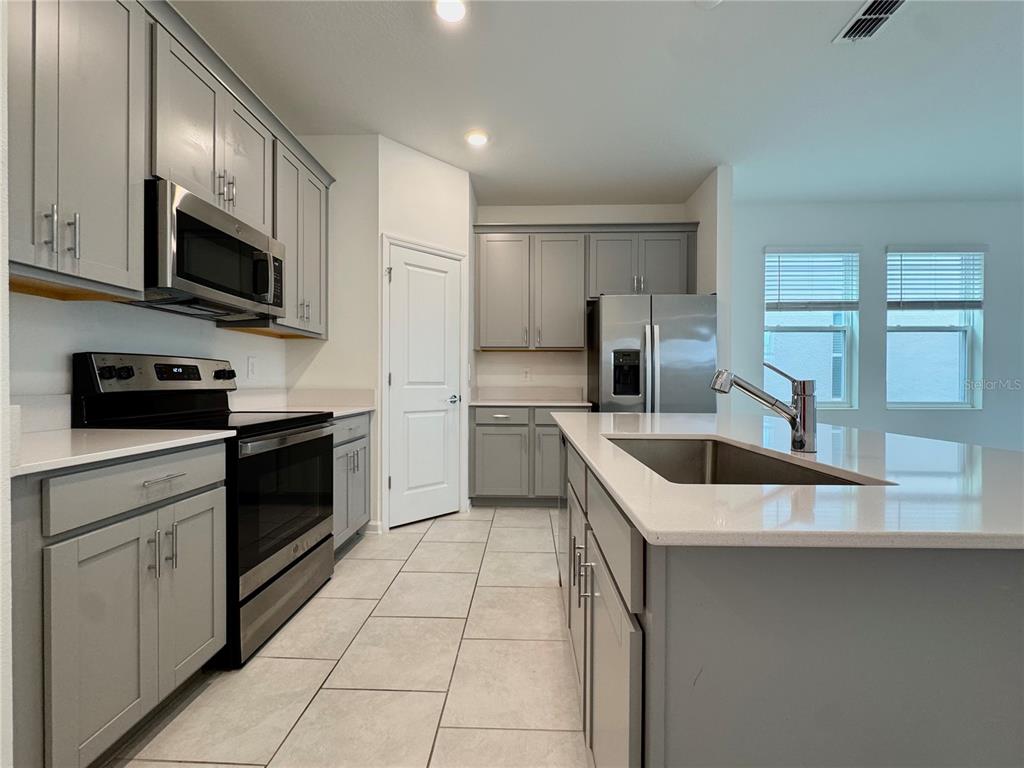 6473 Pine Warbler Way St. Cloud, FL 34771 - Photo 7 of 27 a kitchen with a sink a stove and cabinets