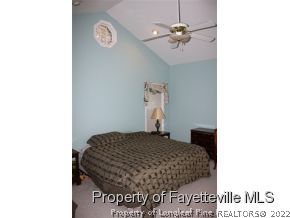 1550 Reservation Road Aberdeen, NC 28315 - Photo 5 of 7 a bedroom with a bed and a chandelier
