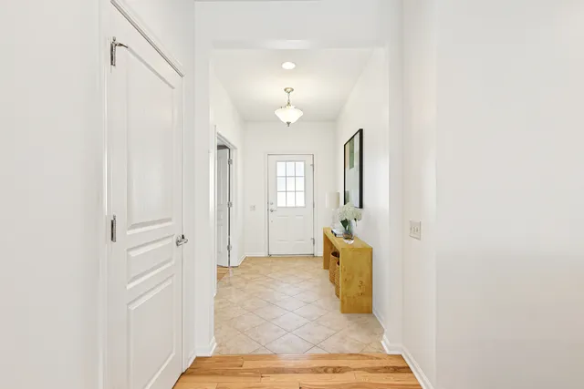 a view of a hallway with wooden floor and cabinet