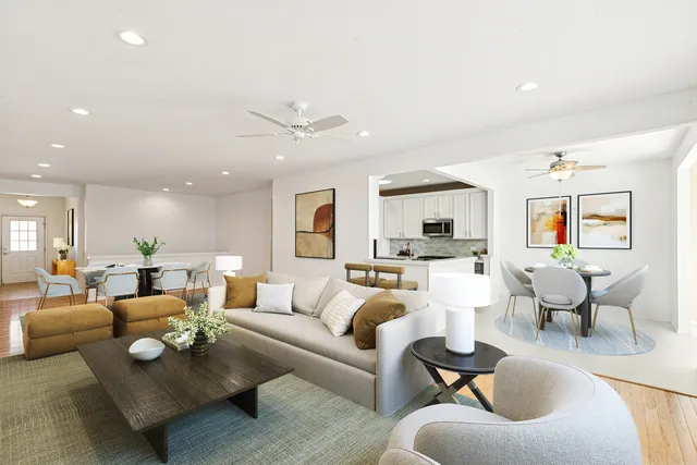 a living room with furniture kitchen view and a large window