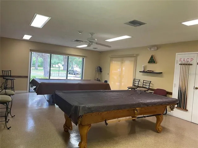 a living room with pool table and windows