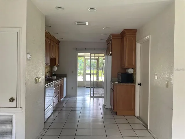 a kitchen with granite countertop a refrigerator and a stove top oven