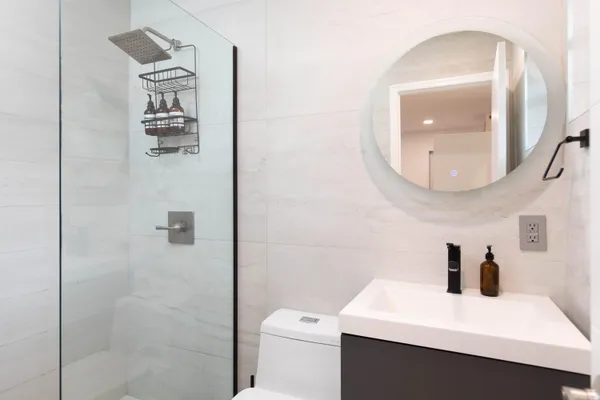 a bathroom with a sink a toilet and mirror