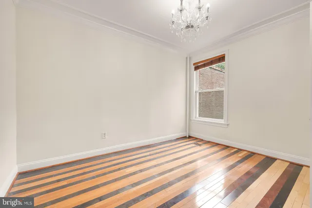wooden floor in an empty room with a window