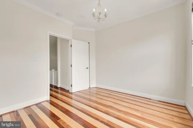 a view of a room with wooden floor and white walls