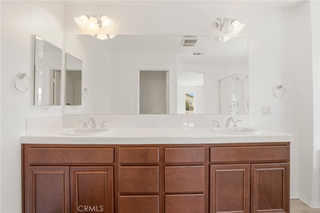 31598-31598 Six Rivers Court Temecula, CA 92592 - Photo 26 of 43 a bathroom with a sink vanity and a mirror