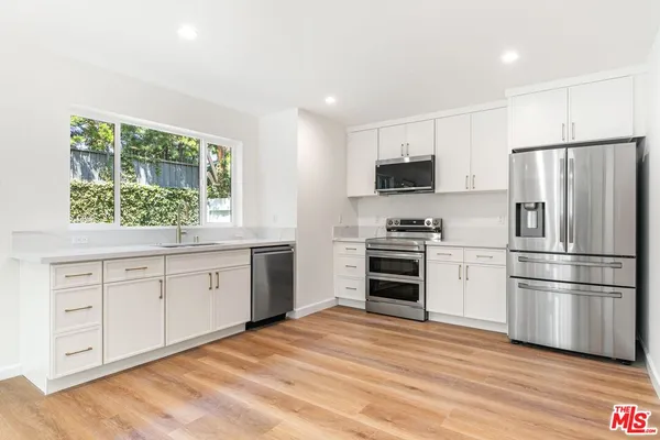 a kitchen with white cabinets and stainless steel appliances