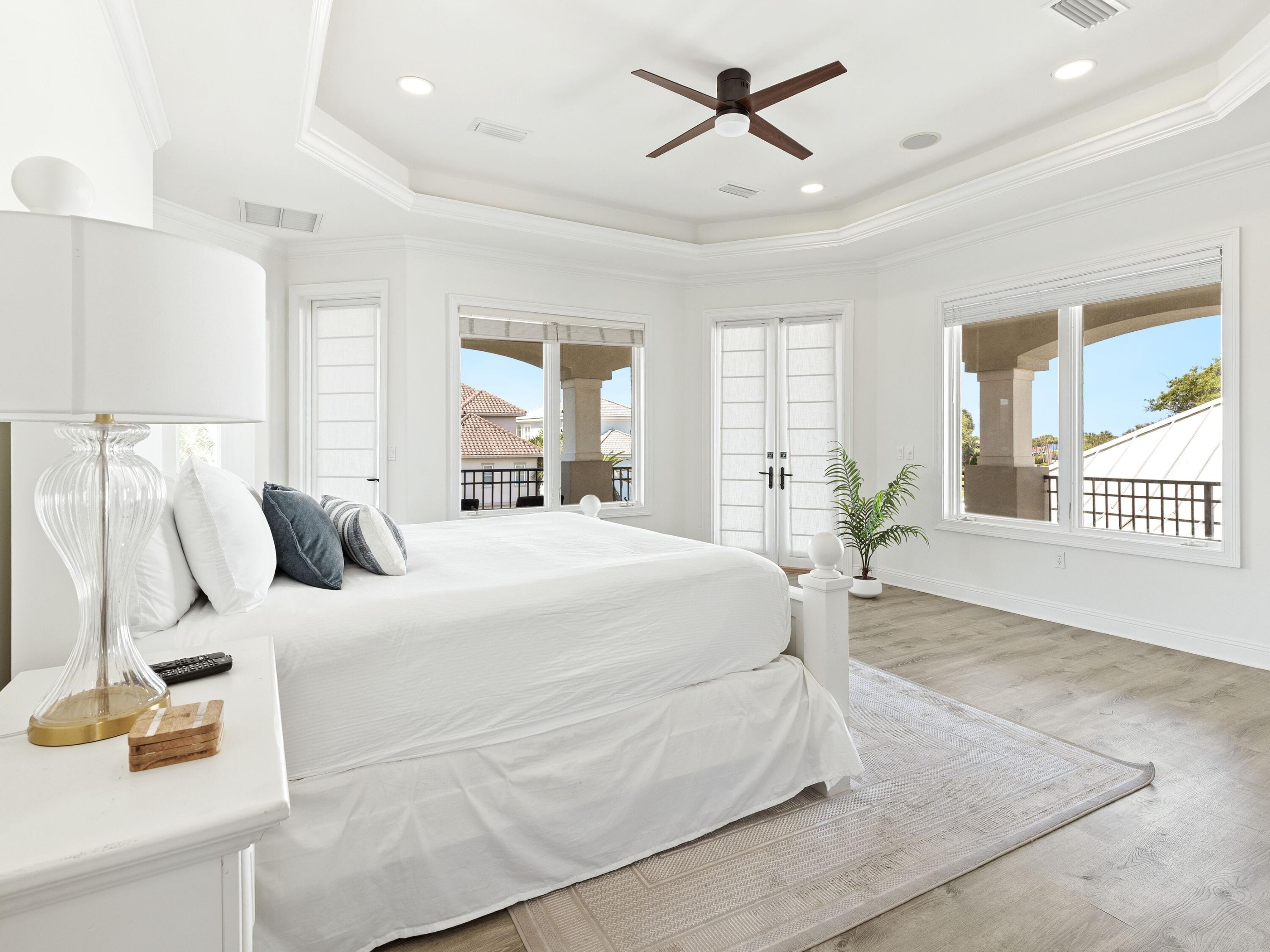 52 Tranquility Lane Destin, FL 32541 - Photo 46 of 65 a spacious bedroom with a large bed and a chandelier