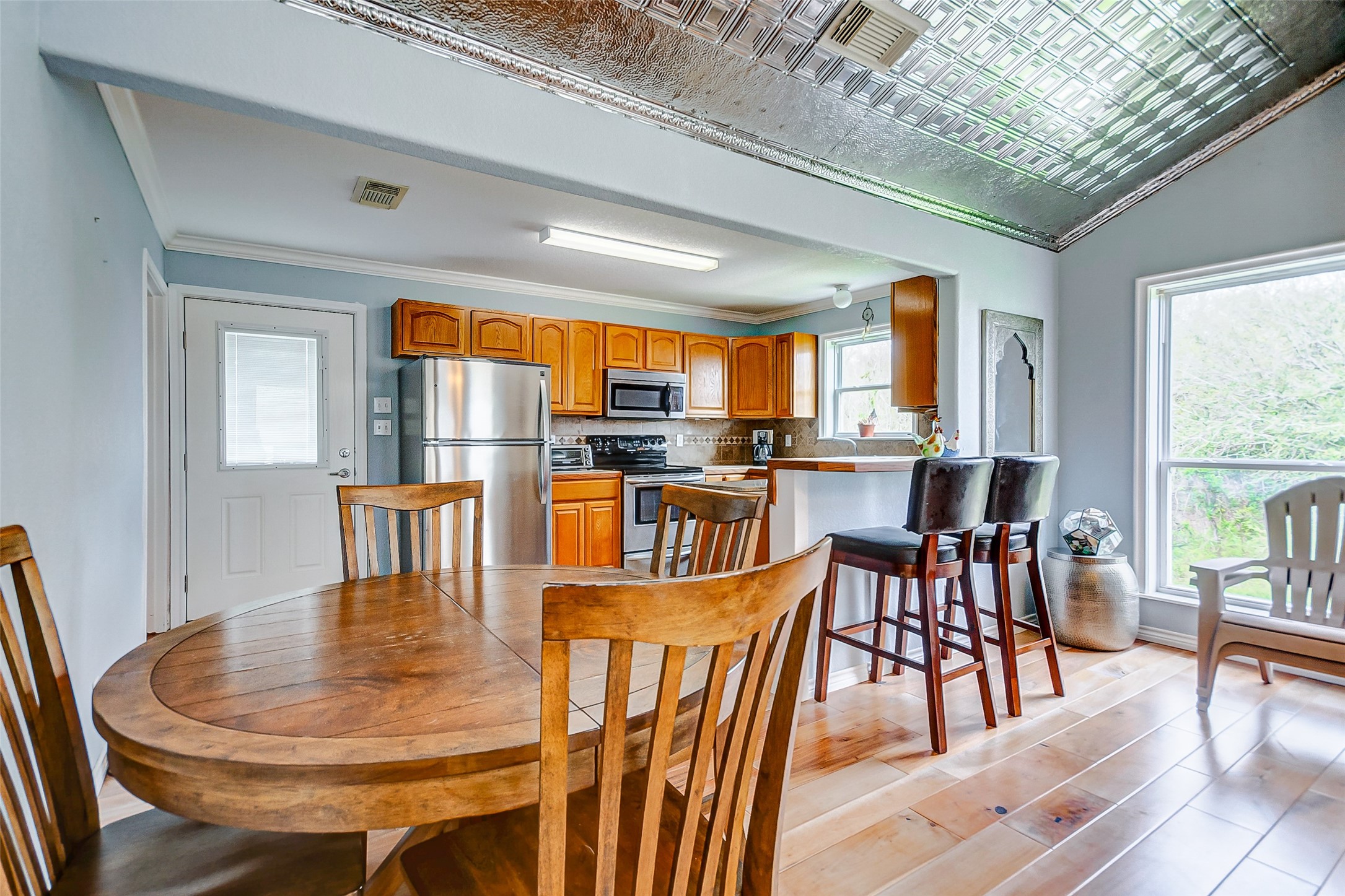 2101 7th Street High Island, TX 77650 - Photo 12 of 33 a dining room with furniture a kitchen view and wooden floor