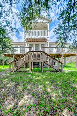 a view of a house with a backyard and a wooden deck