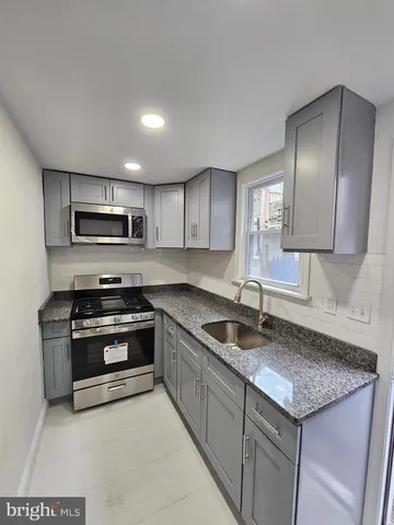 a kitchen with granite countertop a sink and steel appliances