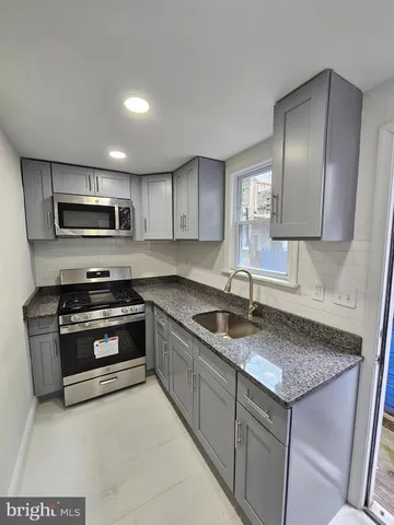 a kitchen with granite countertop a sink and stainless steel appliances