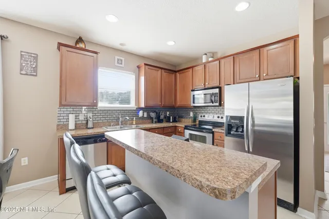 a kitchen with stainless steel appliances granite countertop a sink refrigerator and microwave