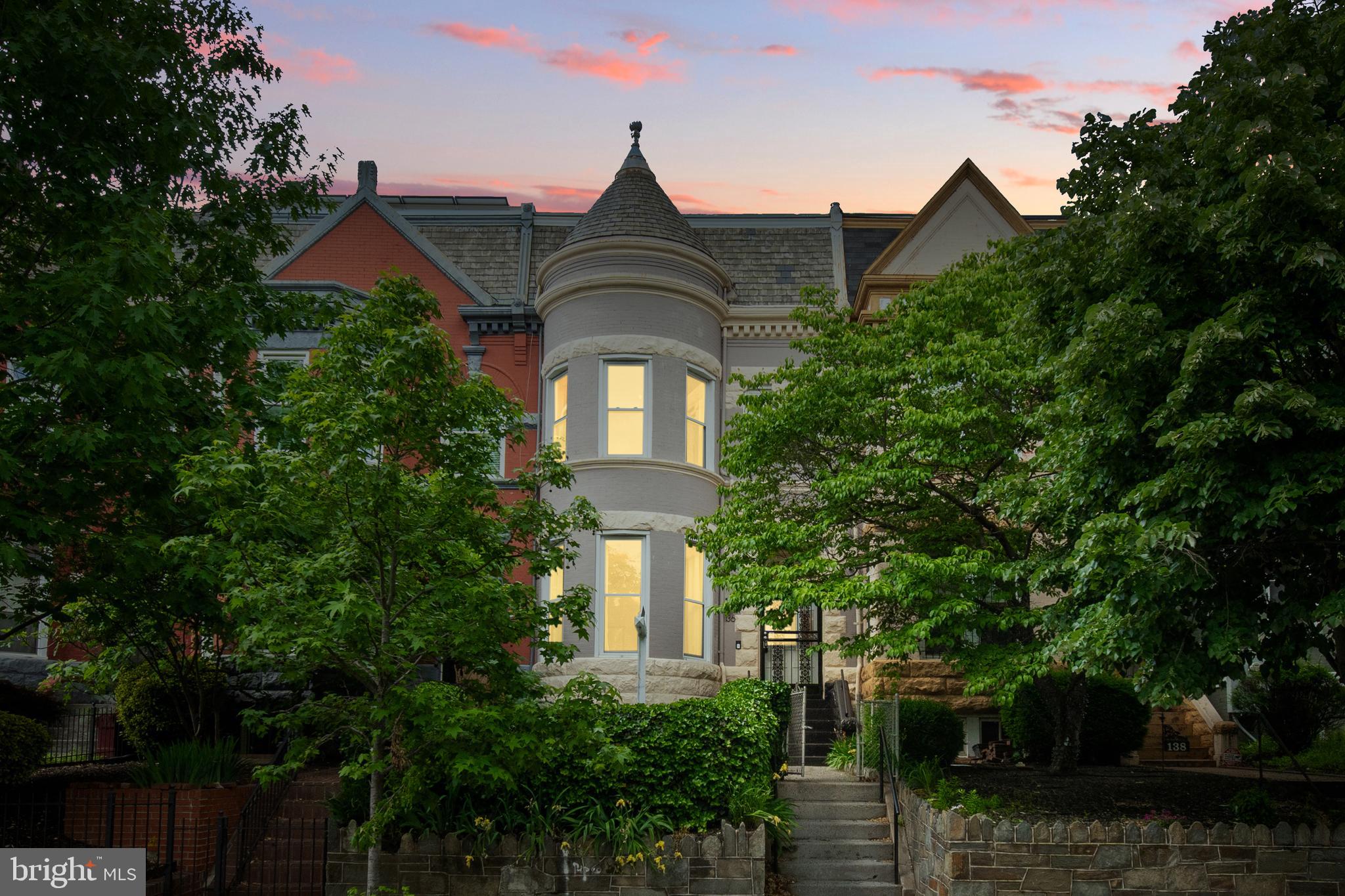 a front view of a house with plants and trees